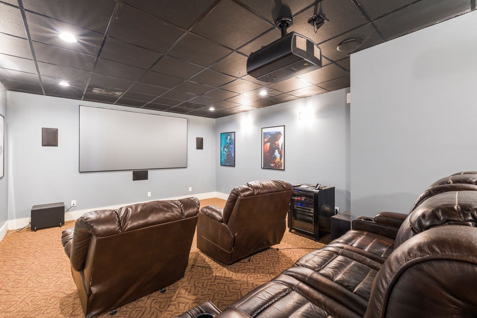 Finished basement home theater in a Utah home with tiered seating and a large projection screen